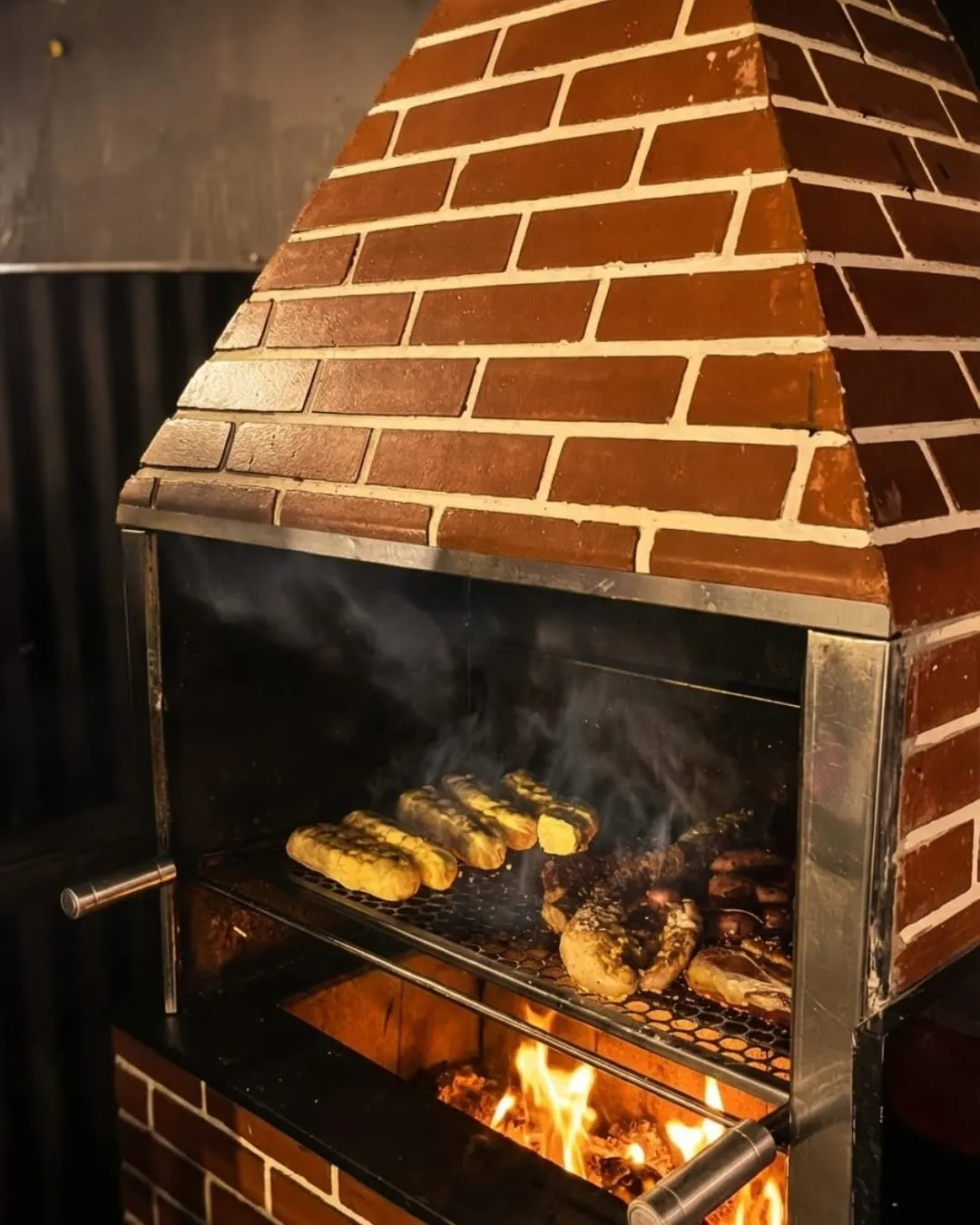 Churrasqueira de tijolos do Levedura com carnes na grelha